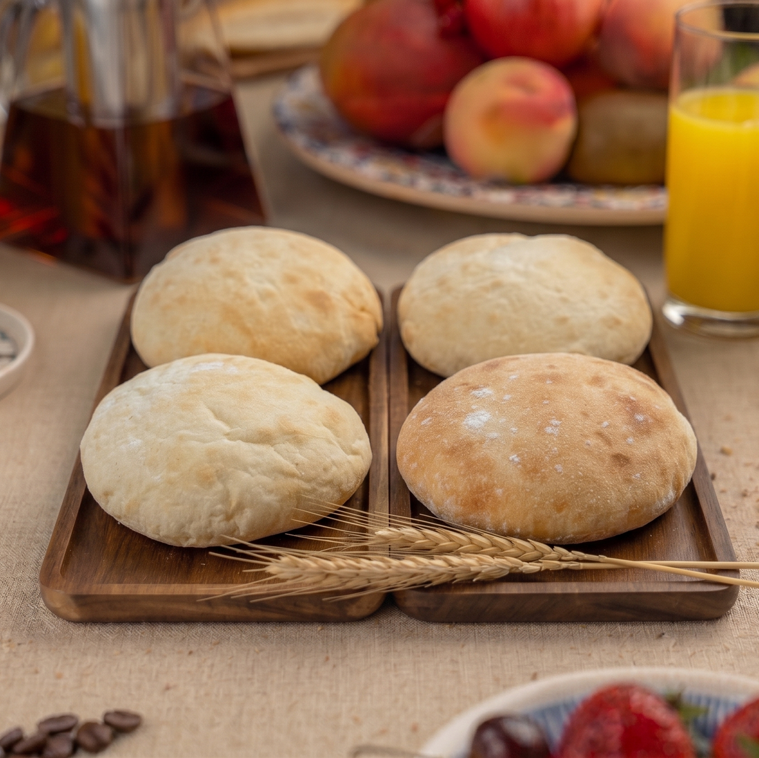 Wooden tray with bagnat bread on a table with fruits and drinks