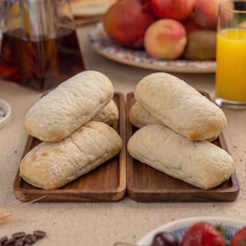 Kebab Bread on wooden trays with a breakfast setting including coffee, orange juice, and fruits.
